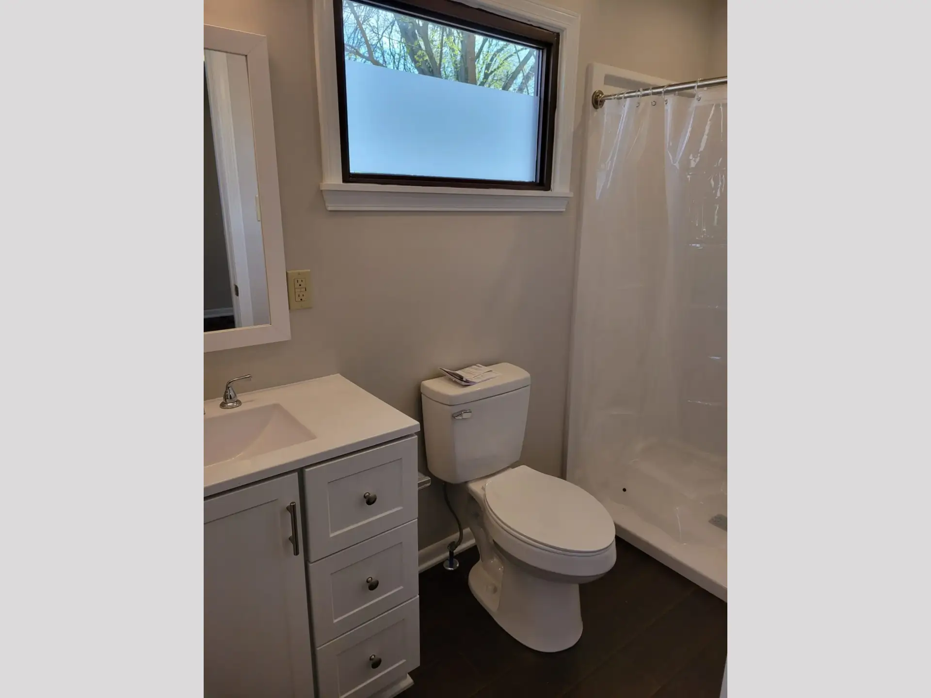 Compact bathroom with white fixtures and a small window.