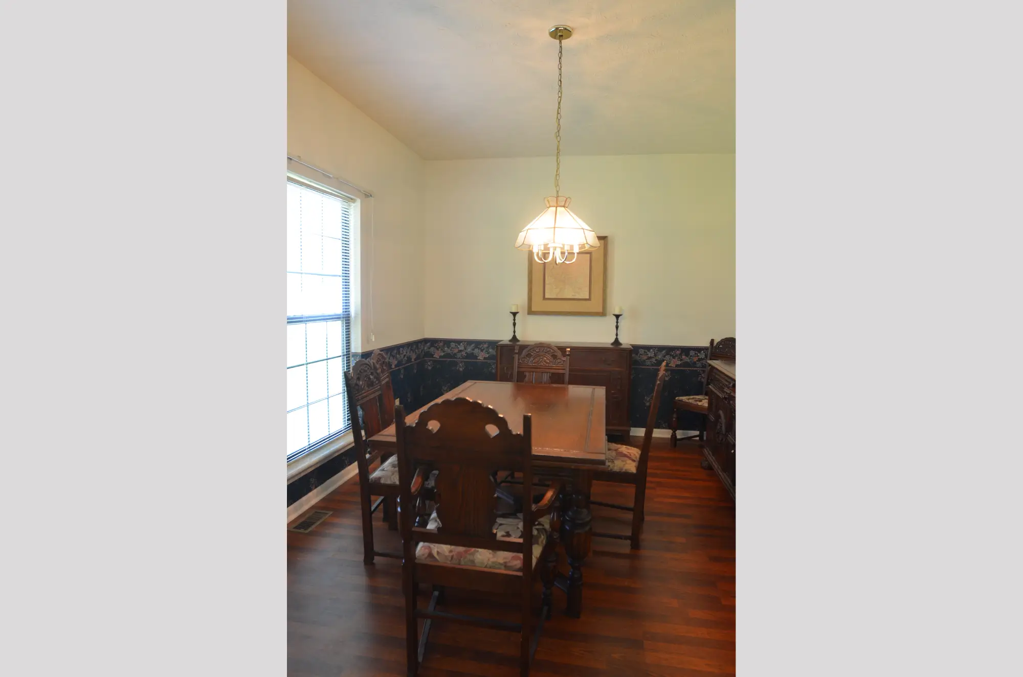 Cozy dining room with wooden furniture and a hanging light fixture.